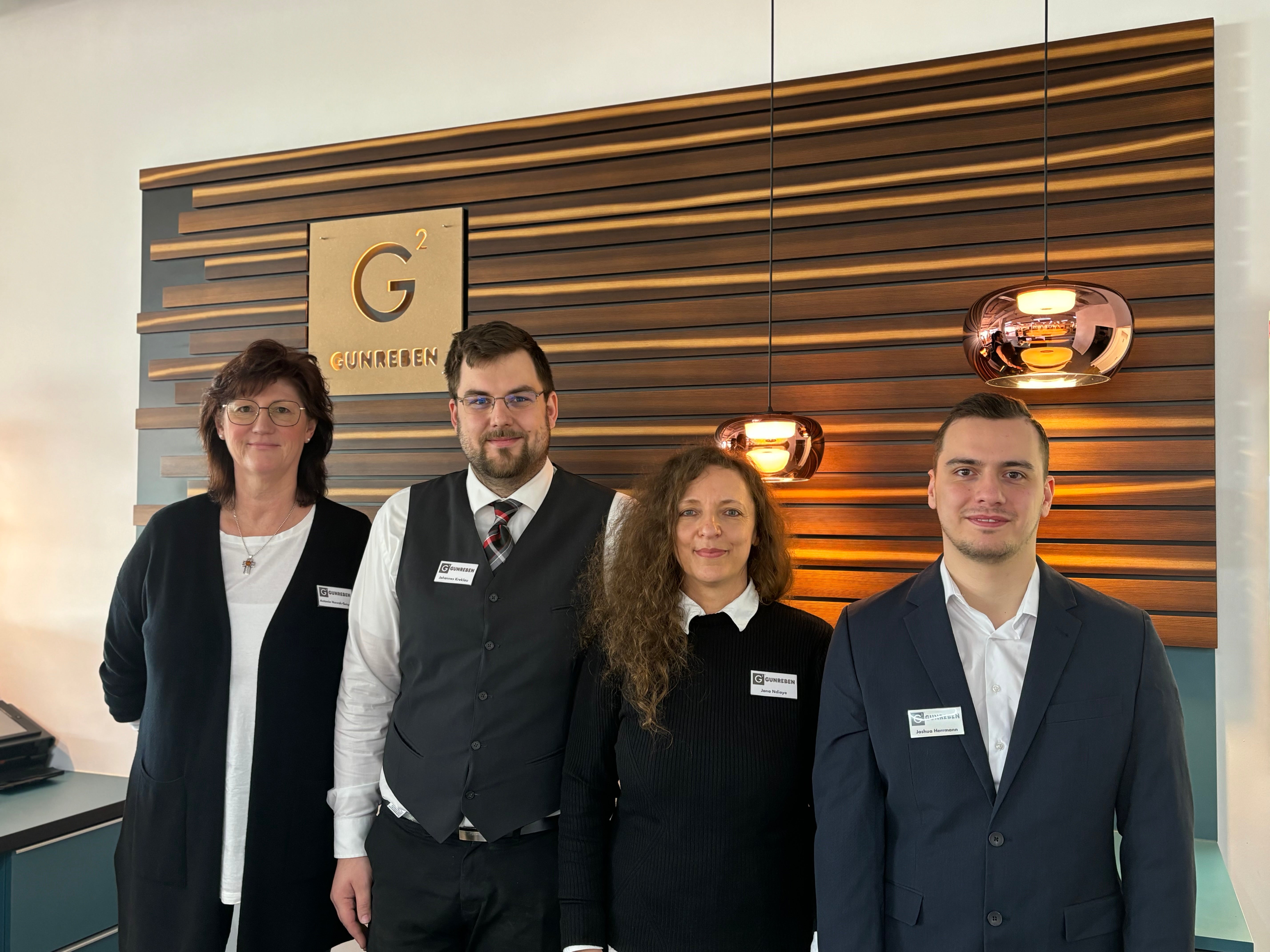 Die Mitarbeiter des Showrooms stehen am Tresen vor dem Gunreben Logo