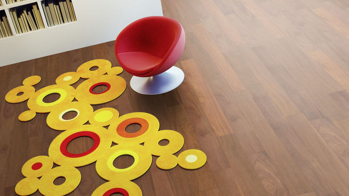 Cumaru Eleganz roh, geschliffen Massivholzdiele 20 × 135 mm – Beispielbild Wohnzimmer mit rotem Stuhl