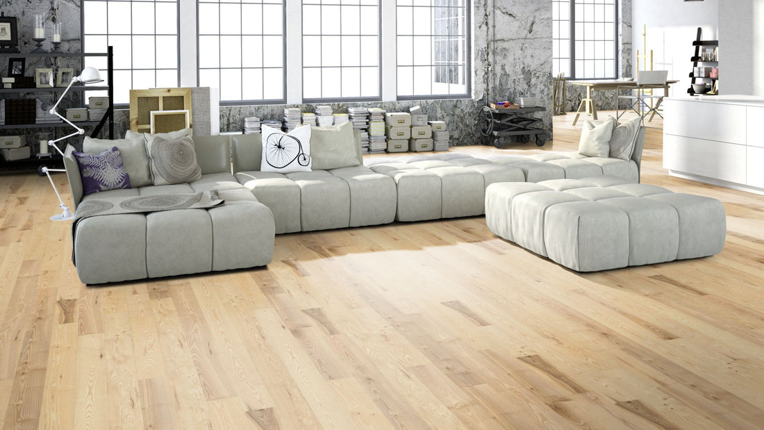 Esche Natur geölt, geschliffen Massivholzdiele 15 × 130 mm – Beispielbild Wohnzimmer mit grauem Sofa