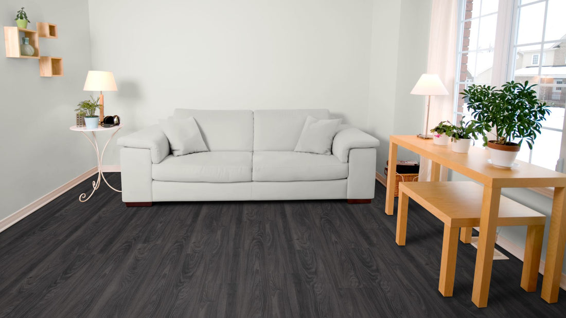 Zeus Traffic Vinyl Designboden Click 5,0 × 182 × 1220 mm – Beispielbild Wohnzimmer mit grauem Sofa